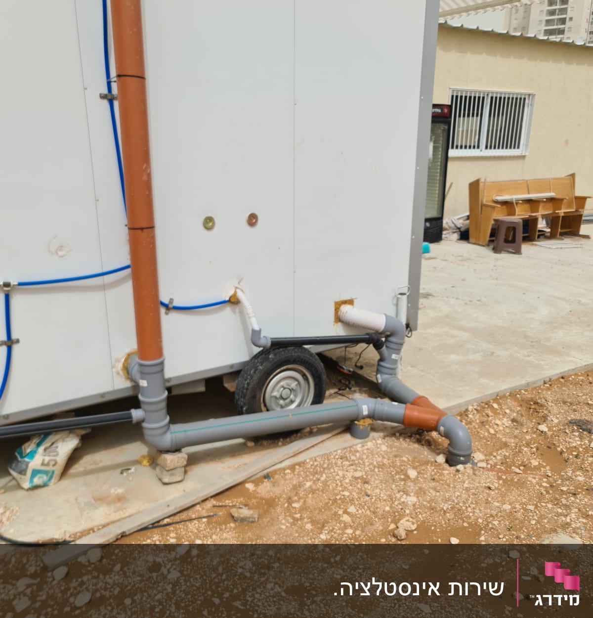 צינורות פלסטיק חומים ואפורים מחוברים לקיר חיצוני